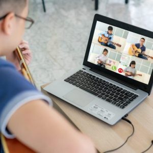 Boy playing guitar with a group of people online