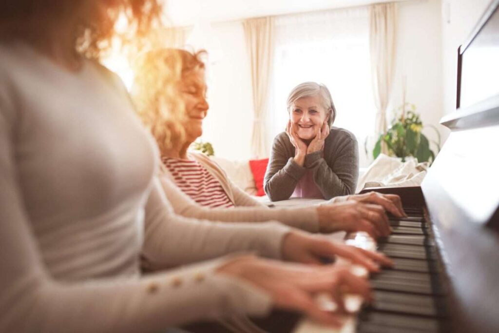 A woman watching another woman participating in music therapy for dementia