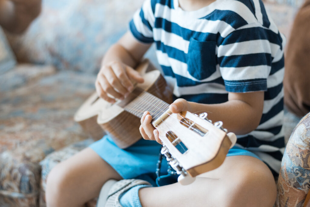 A child plays a ukulele in a music therapy session in Melbourne